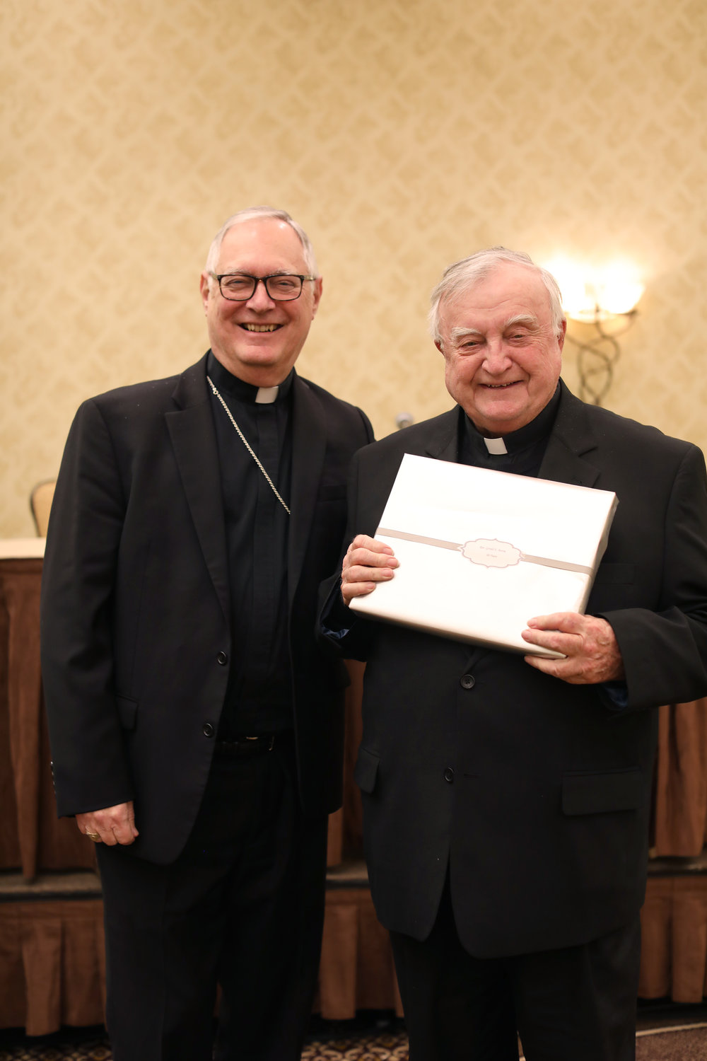 Bishop Tobin congratulates Father Gerald E. Beirne for his 60 years of service. 